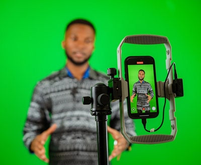 Un jeune journaliste de l'équipe ZOA tourne une vidéo d'explication sur un fond vert